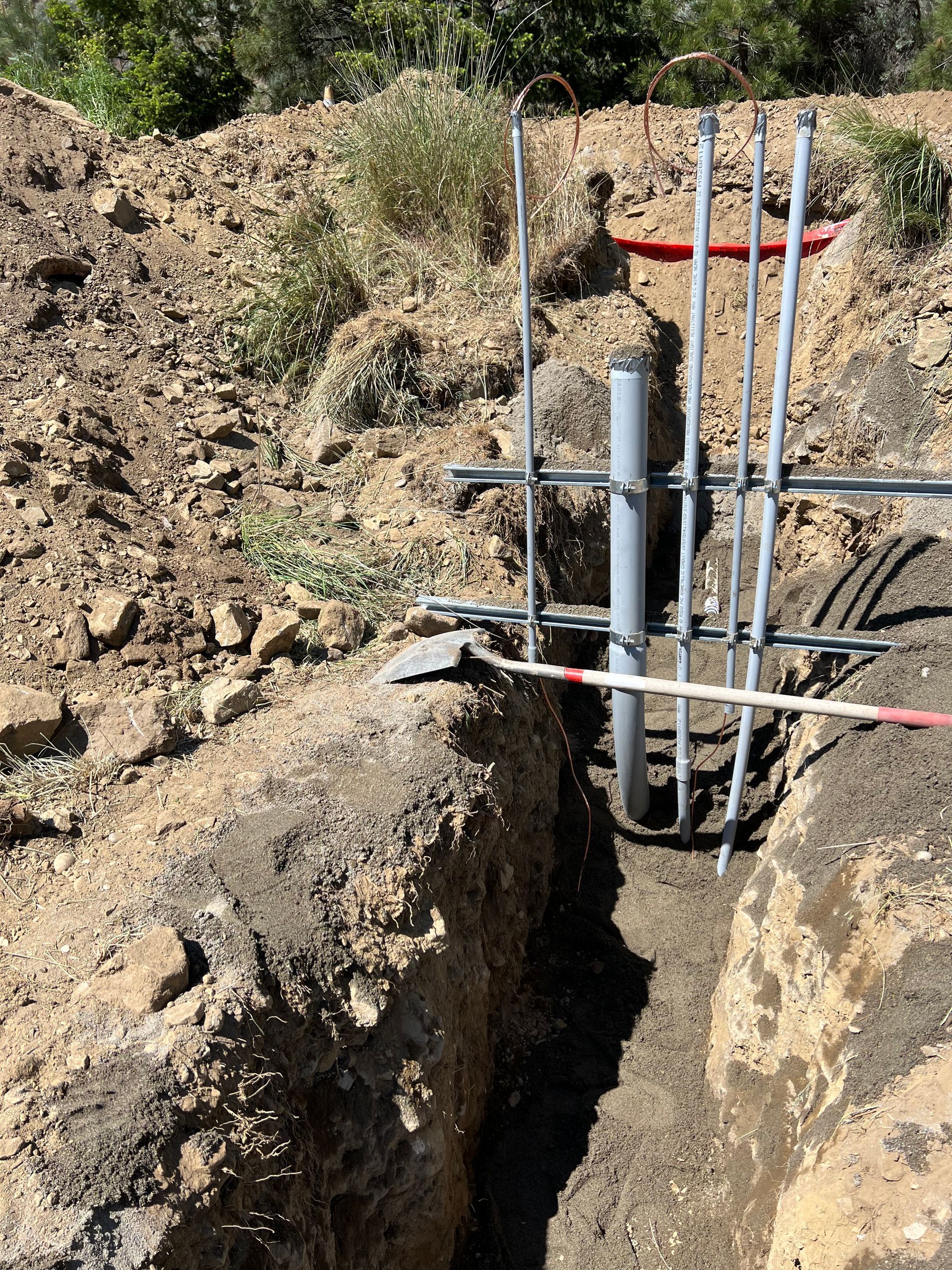 A pipe is being installed in a hole in the ground.