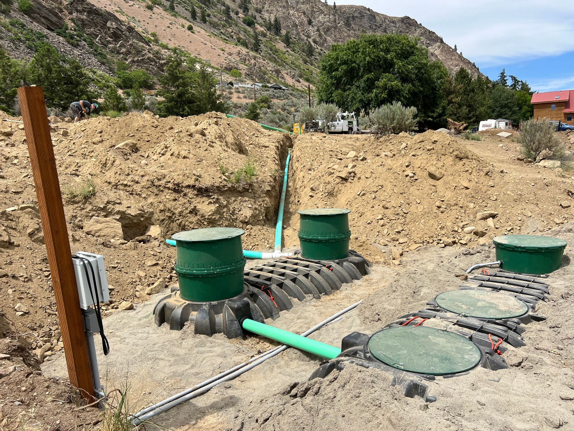 A septic system is being installed in a dirt field.