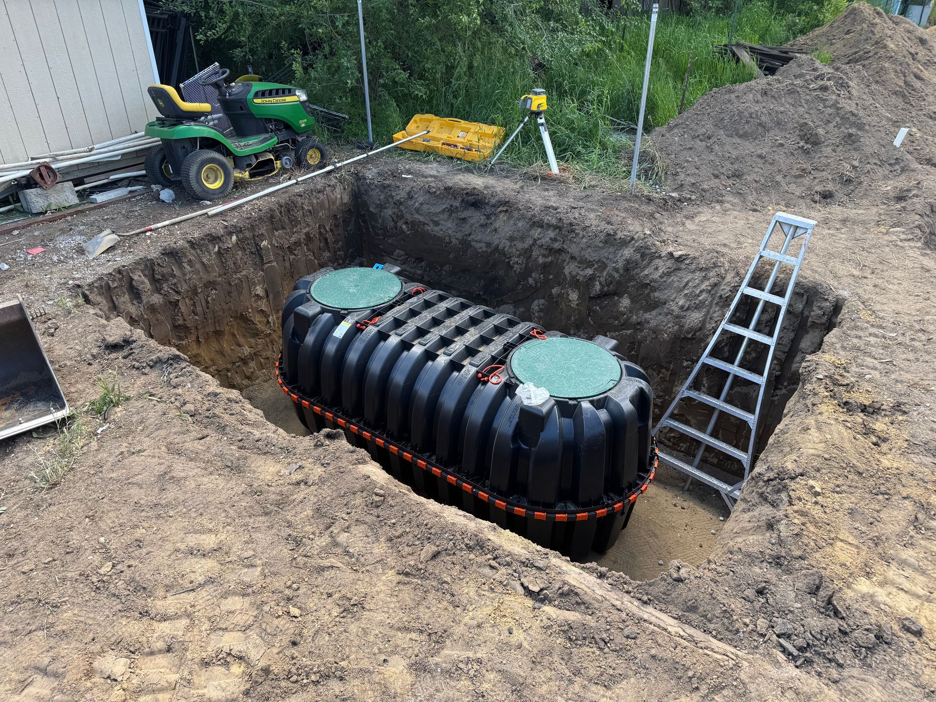 A septic tank is being installed in a hole in the ground.
