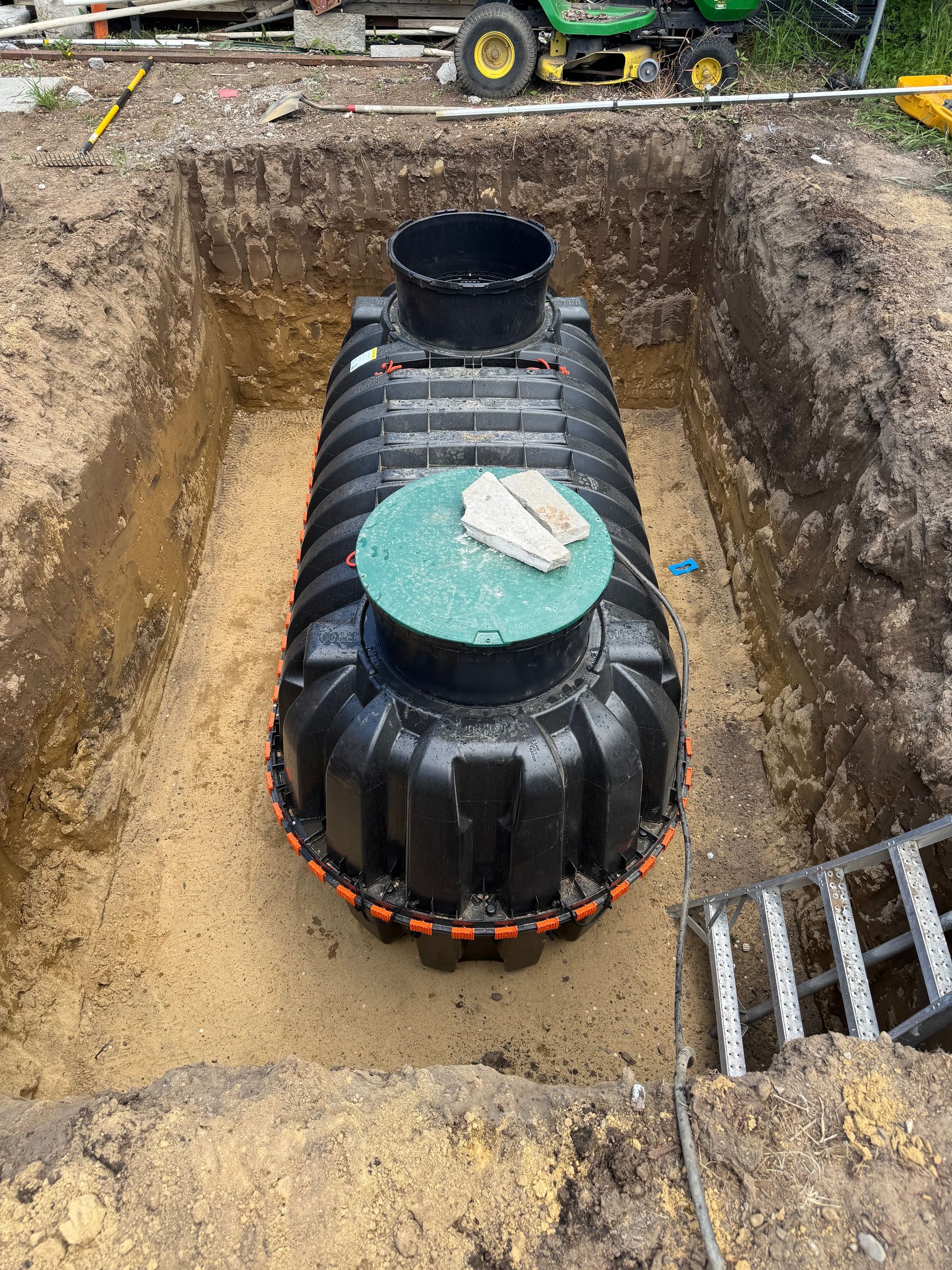 A large black tank is sitting in a hole in the ground.